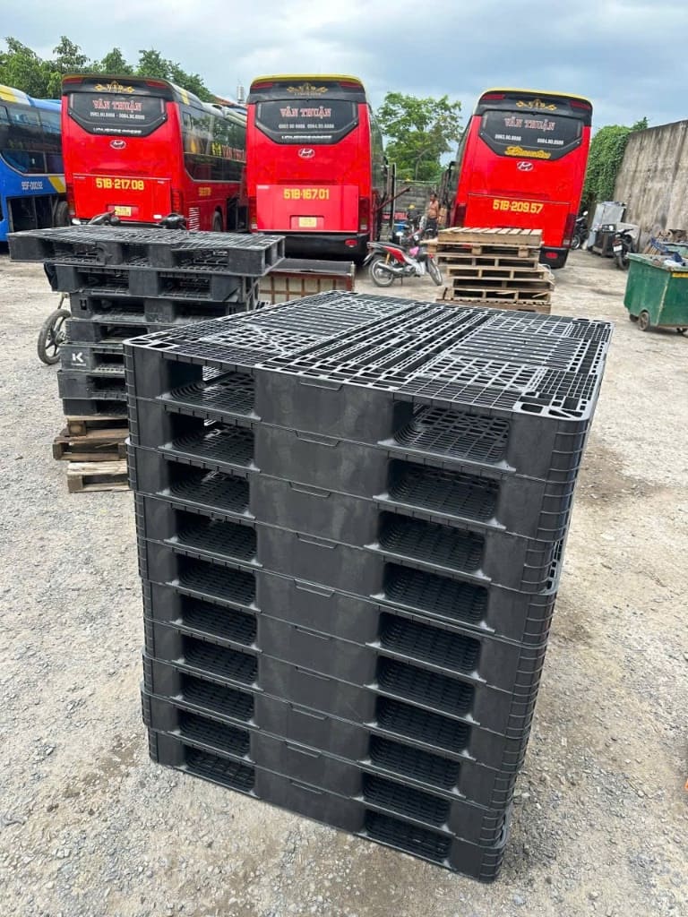 Pallet nhựa đen xếp chồng tại bãi kho ngoài trời chịu thời tiết tốt