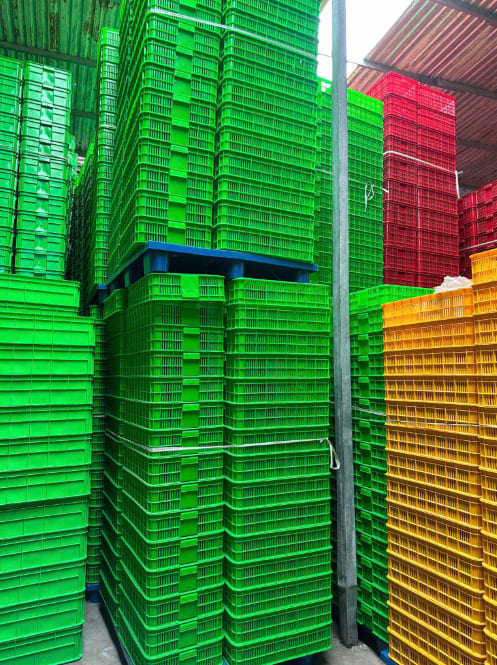 Các cọc sóng nhựa công nghiệp xếp chồng cao trên tấm pallet trong kho