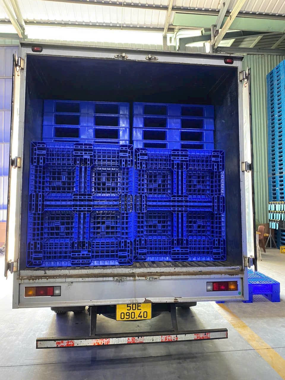 Pallet nhựa xanh mặt lưới xếp vừa vặn trong thùng xe tải thùng kín