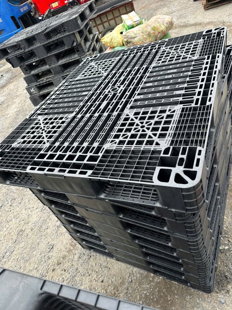Pallet nhựa đen mặt lưới chịu tải nặng 4 hướng nâng